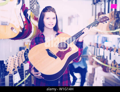 Felici i clienti di adolescenti di decidere su appositi chitarra acustica nel negozio di chitarra Foto Stock