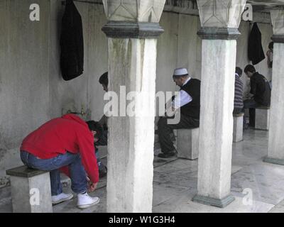 Uomini musulmani lavando loro i piedi prima di entrare nella Moschea Blu per la preghiera. Istanbul, Turchia Foto Stock