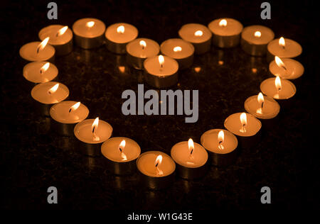 Una disposizione a forma di cuore di luci brucianti del tè. Foto Stock