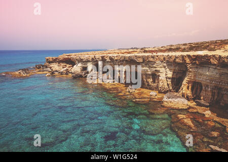 Mare rocciosa costa alla luce del tramonto Foto Stock