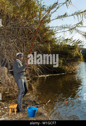 Emotional ritratto di uomo africano tirando con asta di pescare sul fiume Foto Stock
