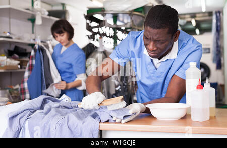 Esperti di afro-americano di uomo che lavora nella moderna Pulitore a secco Foto Stock