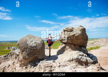 La donna che si estende fra due rocce Foto Stock