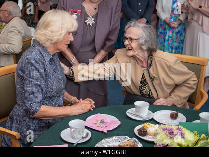 La duchessa di Cornovaglia (sinistra), nel suo ruolo di presidente della Royal il servizio volontario, durante la sua visita alla crusca Dolau pranzo Club per celebrare il club il quarantesimo anniversario a DOL Y Wern in Llandovery. Foto Stock