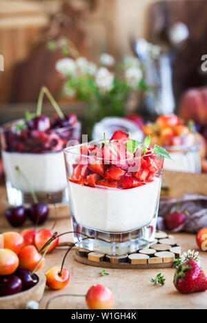 Deliziosi dessert italiano Panna cotta con estate fresca di bacche e frutti Foto Stock