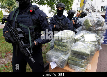 Gli ufficiali di polizia stare in guardia accanto a sacchi di cocaina, che sono stati sequestrati durante una particolare operazione di polizia in occasione di una conferenza stampa della polizia nazionale e il Anti-Narcotic dipartimento di polizia e gli Stati Uniti Dipartimento della Drug Enforcement Administration (DEA) presso il Ministero degli Affari Interni a Kiev.la polizia ucraina in cooperazione con gli Stati Uniti DEA ha rivelato transnazionali di traffico di stupefacenti canale dalla Colombia alla UE e arrestati trafficanti di droga e sequestrato circa 400 kg di cocaina costo stimato di 60 milioni di dollari, che dovevano essere trasferiti dall'America Latina attraverso l'Ucraina a Foto Stock