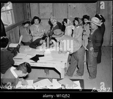 Manzanar Relocation Center, Manzanar, California. Agli sfollati di ascendenza giapponese la firma per il lavoro . . .; Portata e contenuto: tutta la didascalia per questa fotografia si legge: Manzanar Relocation Center, Manzanar, California. Agli sfollati di ascendenza giapponese la firma per lavorare a questa guerra Autorità di Relocation Center. Foto Stock