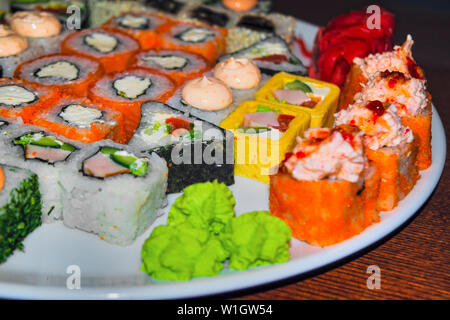 Grande piastra di vari sushi con pesce, pesce e riso in bianco. Piastra con diversi tipi di sushi. Foto Stock