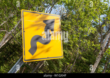 La torsione cartello stradale su un American road. Foto Stock