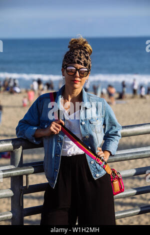 La mezza età della donna in posa con sfumature in Santa Monica Pier e Spiaggia di Los Angeles in California Foto Stock