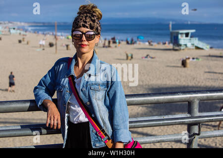 La mezza età della donna in posa con sfumature in Santa Monica Pier e Spiaggia di Los Angeles in California Foto Stock