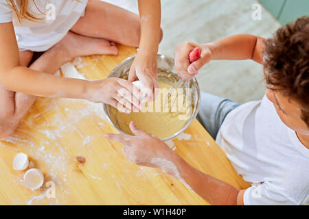 Dei bambini felici la cottura di dolci fatti in casa in cucina Foto Stock