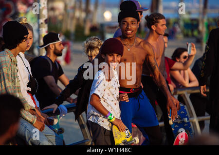 I giovani skaters abbracciando in skate park in Venice Beach, Los Angeles, California, Stati Uniti d'America Foto Stock