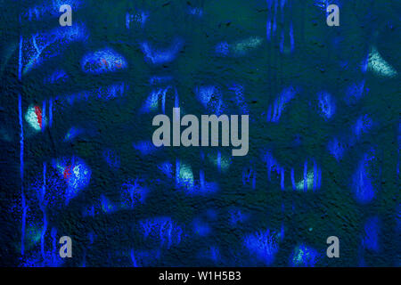 Frammento di scuro di sporco e macchiato parete con la vecchia vernice scheggiato in blu e i colori indietro, graffio, grunge texture di close-up. Moderno sfondo astratto Foto Stock