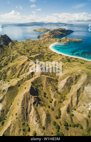 Antenna vista verticale di Padar isola nel Parco Nazionale di Komodo, Indonesia. Drone shot, vista dall'alto. Vista Montagna e spiaggia tropicale. Foto Stock