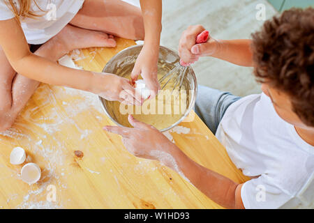 I bambini le piccole mani battete la pasta per frittelle cucina in cucina Foto Stock