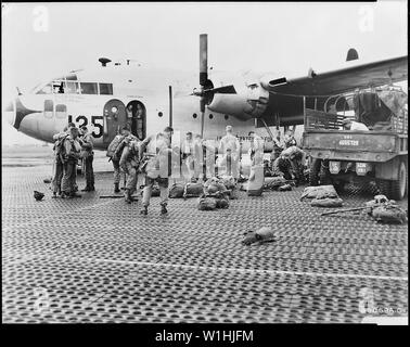 Paracadutisti del reggimento 187th combattere Team hanno messo in paracadute e Mae West ciambelle salvagente prima di salire a bordo di una truppa 483rd ala portante U.S. Air Force C-119 Flying Boxcar, in rotta verso la Corea del sud giappone; Portata e contenuto: i paracadutisti del Reggimento 187th combattere Team hanno messo in paracadute e Mae West ciambelle salvagente prima di salire a bordo di una truppa 483rd ala portante U.S. Air Force C-119 Flying Boxcar, in rotta verso la Corea del sud giappone. La lotta contro il carico Commandos e C-119s trasferito in aereo il 187th RCT personale e armi, veicoli e materiali di consumo in un funzionamento continuo della durata di due notti di un Foto Stock