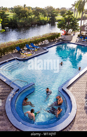 Miami Florida,Wyndham Miami Airport,hotel,catena,alloggio,esterno,ingresso,piscina,terrazza,poltrona,uomo maschio,nuoto,ospite,canale,golf Foto Stock