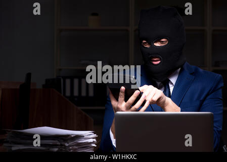 Dipendente di sesso maschile di rubare informazioni in ufficio tempo di notte Foto Stock