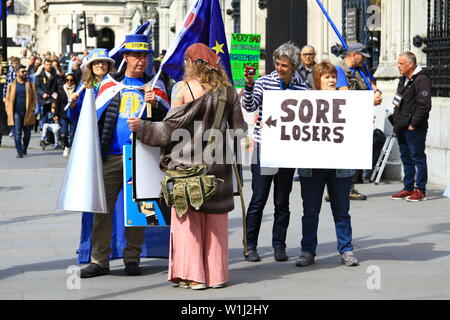 Sostenitori BREXIT TENERE UN SEGNO mal di perdenti con una freccia che punta verso un fermo sostenitore BREXIT IN PIAZZA DEL PARLAMENTO, WESTMINSTER, LONDON, Regno Unito il 7 maggio 2019. Foto Stock