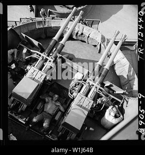 Sailor addormentato tra 40mm cannoni a bordo della USS New Jersey (BB-62). Foto Stock