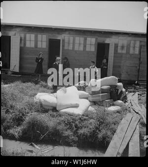 San Bruno, California. Il gruppo di questo centro è stato aperto per soli due giorni. Bus-carico dopo il bus-lo . . .; Portata e contenuto: tutta la didascalia per questa fotografia si legge: San Bruno, California. Il gruppo di questo centro è stato aperto per soli due giorni. Bus-carico dopo il bus-carico di evacuare il giapponese sono arrivate oggi. Dopo il passaggio attraverso la procedura necessaria, essi sono guidati per i trimestri a loro assegnata in caserma. Questa famiglia aveva appena arrivati. Il loro letto e i vestiti sono stati consegnati dal carrello e sono visti impilati nella parte anteriore del cavallo ex-stallo a cui sono stati assegnati. Nazioni Unite Foto Stock