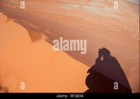 Ombra del fotografo (Amos Gal RIP)su una duna di sabbia ridge al Sossusvlei, Namib-Naukluft National Park, Namibia. Foto Stock