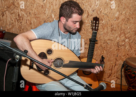 Giovane musicista caucasica svolge un Oud un breve collo liuto-tipo, a forma di pera strumento a corda Foto Stock