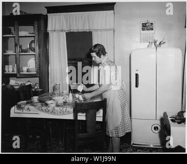 Shelby County, Iowa. Cucina e soggiorno in dimora di una di medie dimensioni proprietari operato farm. . . .; Portata e contenuto: Full didascalia recita come segue: Shelby County, Iowa. Cucina e soggiorno in dimora di una di medie dimensioni proprietari operato farm. La casa è semplicemente ma arredate in modo confortevole e dispone di tutti i più moderni di base -- la luce elettrica e refrigerazione, radio, e acqua in cucina. Notare, tuttavia, che l'acqua deve essere pompato a mano. Il pasto appena finito -- Cena -- era abbondante e variata e ben preparato. Foto Stock