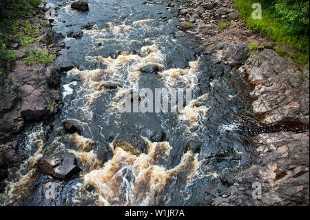 Radice birra acqua colorata bolle in Bad River Gorge in rame scende stato parco nel Northwoods di Wisconsiln vicino Mellen. (C) 2014 Tom Kelly Foto Stock