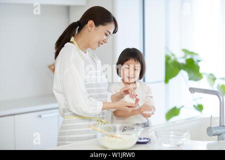 Donna giapponese con la figlia in cucina Foto Stock