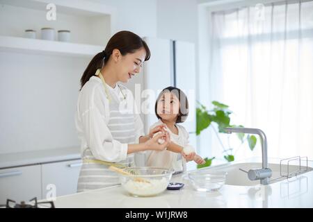 Donna giapponese con la figlia in cucina Foto Stock