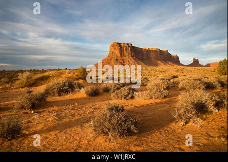 Il deserto di sabbia si accese al tramonto come il sole invernale imposta su Eagle Rock e la gallina di seduta in Monument Valley, Utah. (C) 2011 Tom Kelly Foto Stock