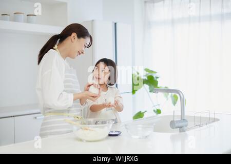 Donna giapponese con la figlia in cucina Foto Stock