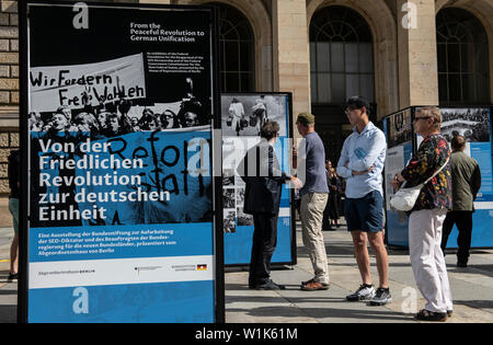 Berlino, Germania. 03 Luglio, 2019. Le persone sono in piedi di fronte a pannelli informativi presso la Casa dei Rappresentanti. Essi fanno parte del nuovo open-air mostra 'dalla rivoluzione pacifica all'Unità tedesca", organizzato dall'Bundesstiftung zur Aufarbeitung der SED-Diktatur. L'occasione per la presentazione è il prossimo trentesimo anniversario della caduta del muro di Berlino. Credito: Paolo Zinken/dpa/Alamy Live News Foto Stock