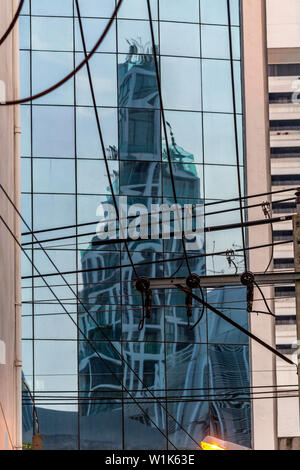 Grattacielo riflesso sui vetri di un edificio moderno a Bangkok Foto Stock