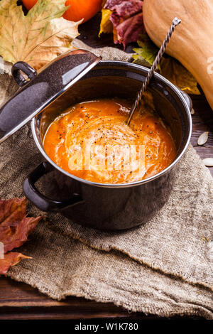 Immagine della purea di zuppa in casseruola, zucca sopra panno di tela Foto Stock