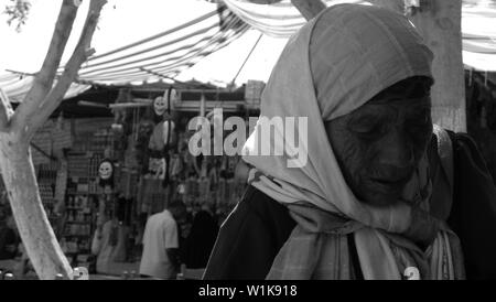 Una foto in bianco e nero per una vecchia donna vendita di quotidiani a Marsa Matrouh, Egitto Foto Stock