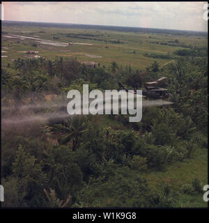 Il Vietnam. Defogliazione missione. Un UH-1D elicottero dall'336a società di aviazione spruzza un defogliazione agente su una giungla fitta area nel delta del Mekong.; note generali: La foto è invertita. Foto Stock