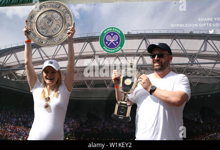 Spettatori pongono con tagli di cartone outs dei trofei all'inizio della giornata su tre dei campionati di Wimbledon al All England Lawn Tennis e Croquet Club di Londra. Foto Stock