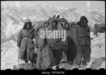 In attesa, in attesa. Questi sintomi di congelamento vittime della merlati Prima Divisione Marine e della settima divisione di fanteria che ha legato fino al serbatoio di Chosin area in un disperato tentativo di rompere l accerchiamento comunista attendere con set di espressioni sui loro volti per il ritiro da piani di U.S. Air Force Estremo Oriente combattere il comando di carico . Aeromobili in arrivo effettuato forniture, razioni, e munizioni per le truppe. Foto Stock