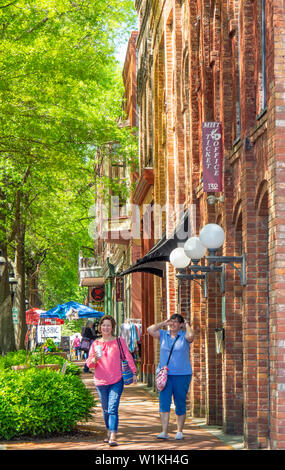 Due femmina quilters camminando lungo la casa mercato piazza durante la settimana del Quilt 2019 Paducah Kentucky negli Stati Uniti. Foto Stock