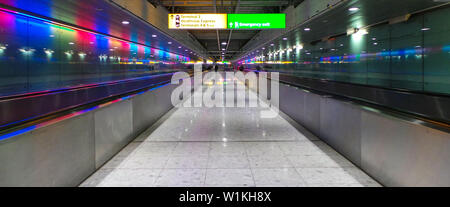 London, Regno Unito - 11 Aprile 2014: colorate luci al neon decorare un corridoio che conduce all aeroporto di Heathrow Foto Stock