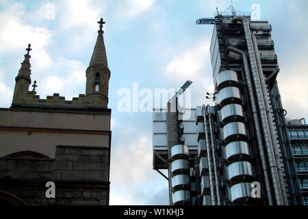 Londra, Inghilterra - 08 Marzo 2004: le guglie di contrasto del Lloyd Building e Sant'Andrea Chiesa torre Foto Stock