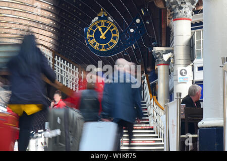 Passeggeri in transito orologio stazione correre per prendere i treni presso la stazione ferroviaria di York Regno Unito Foto Stock