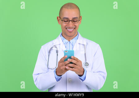 Felice bald multi etnico medico uomo usando il telefono Foto Stock