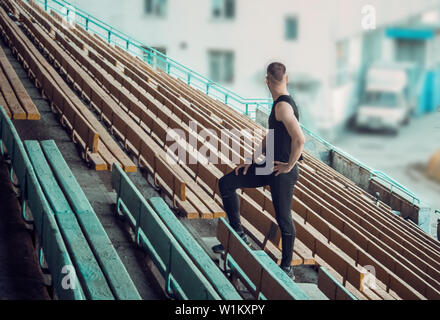 Uomo caucasico treni in esecuzione su per le scale. La via e il campo runner in uniforme di sport outdoor training. atleta, vista dall'alto. passo esercizi. Foto Stock