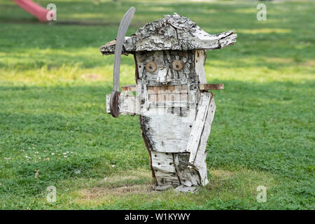 Descrizione: una scultura in legno di schiaccianoci fatti a mano da birch su uno sfondo di erba Foto Stock