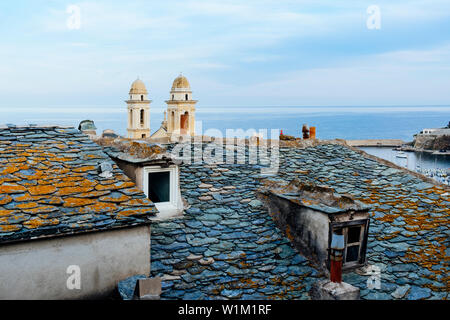 I caratteristici campanili gemelli della chiesa di San Giovanni Battista, in Bastia, Corsica, Francia, evidenziando al di sopra del vecchio dei tetti di ardesia della vecchia Foto Stock