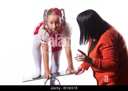 Il trainer insegna al bambino. Circus insegnante spiega alla ragazza come eseguire un trick difficile. Giovani equilibrist circus attrice. Foto Stock